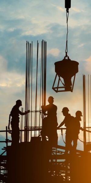 Silhouette of engineer and construction team working safely work load concrete on scaffolding on high rise building. over blurred background sunset pastel for industry background with Light fair